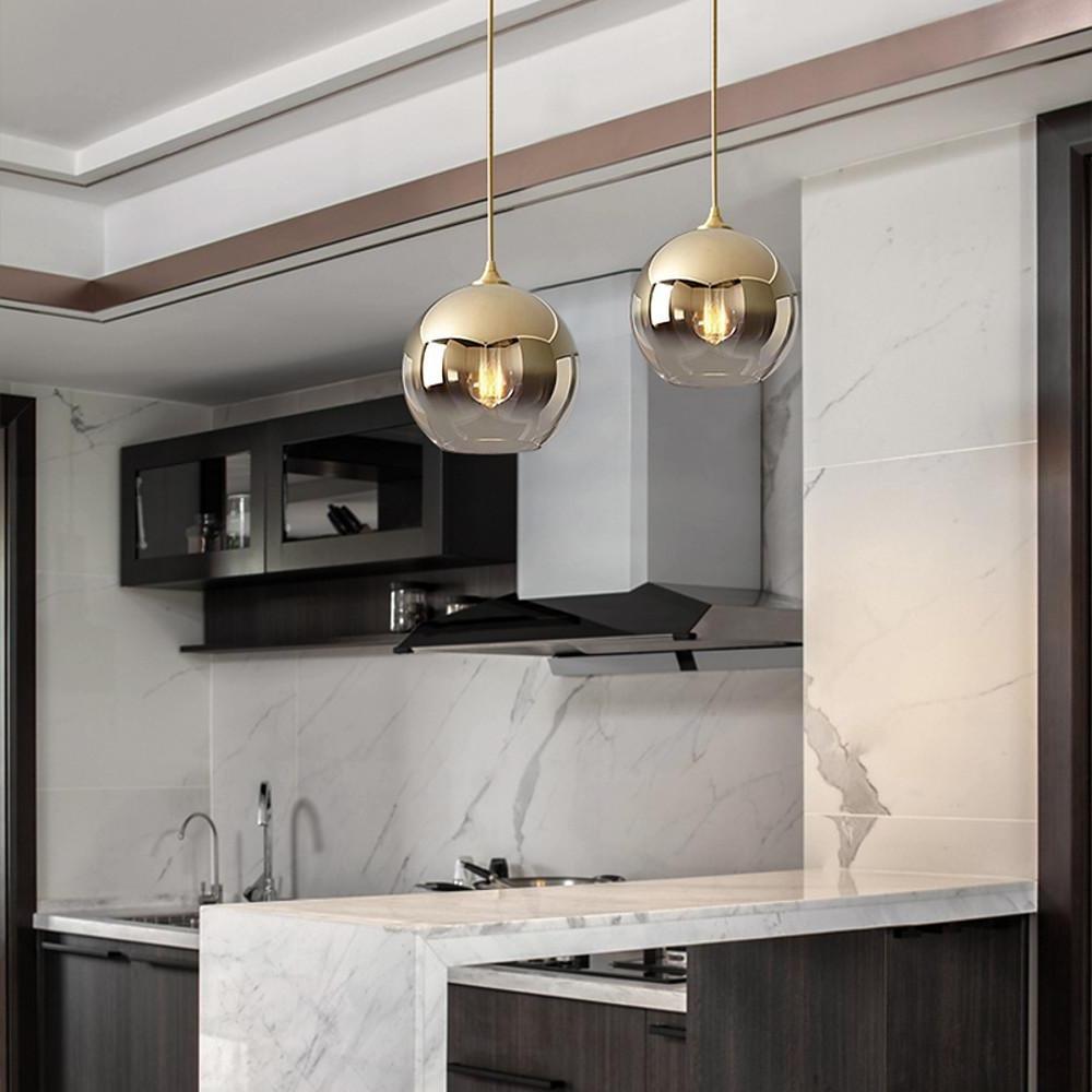 Glass round pendant light paired with a marble kitchen backsplash.