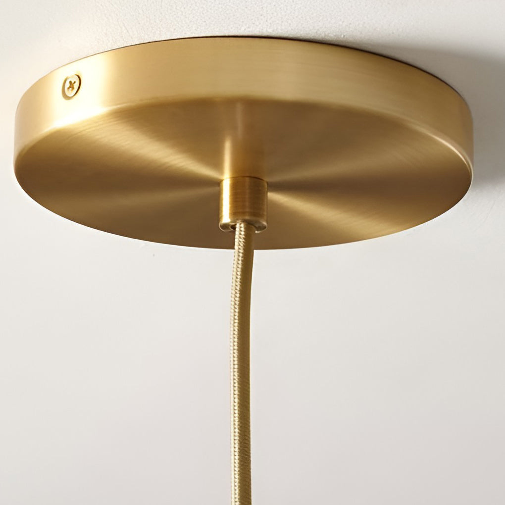 Glass round pendant light centered above a round dining table.