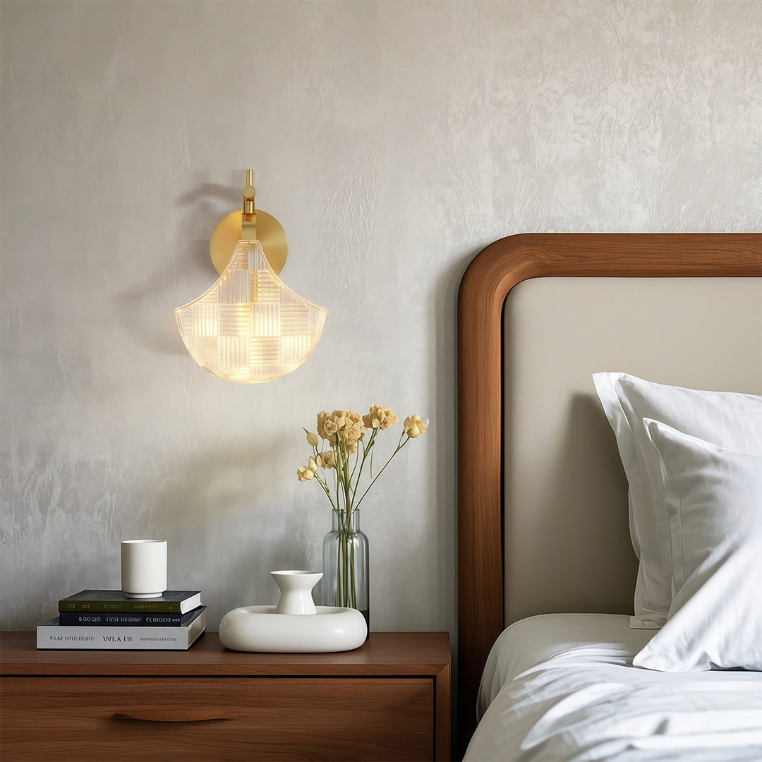 Glass wall sconces creating cozy atmosphere above wooden nightstand with flowers