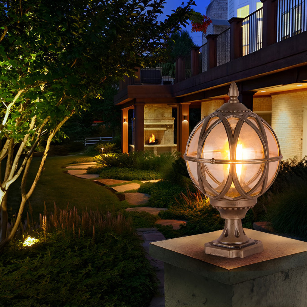 Globe pillar lights with vintage bronze frame illuminating garden pathway near modern house.