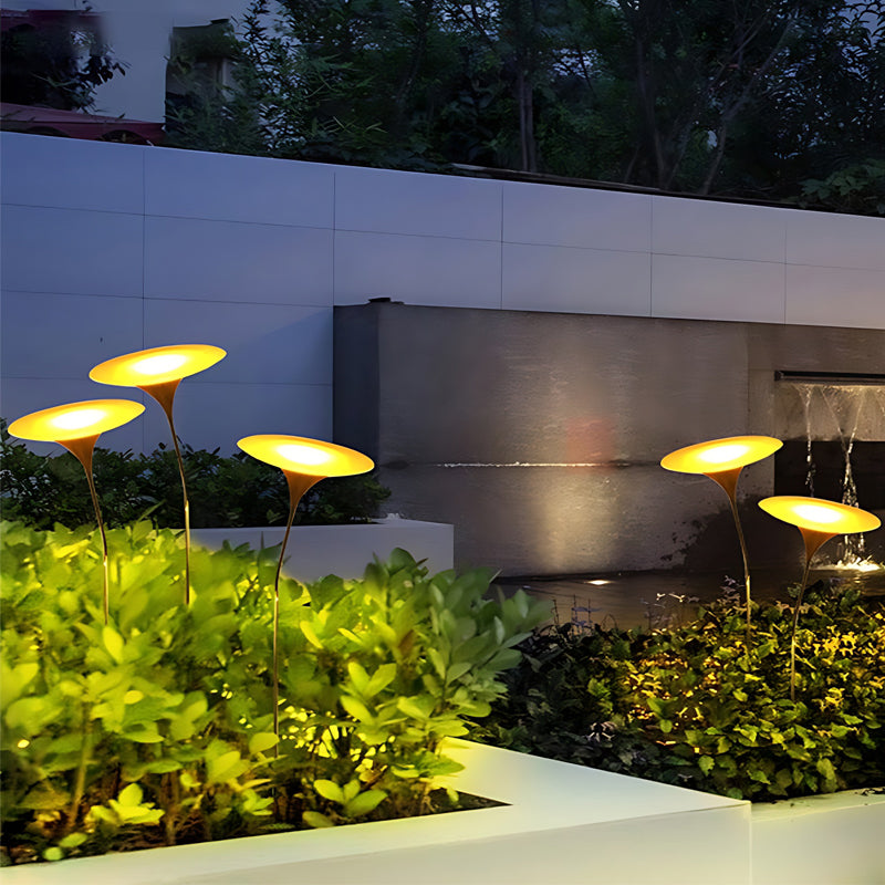Glowing mushroom garden light providing warm light beside a wooden fence.