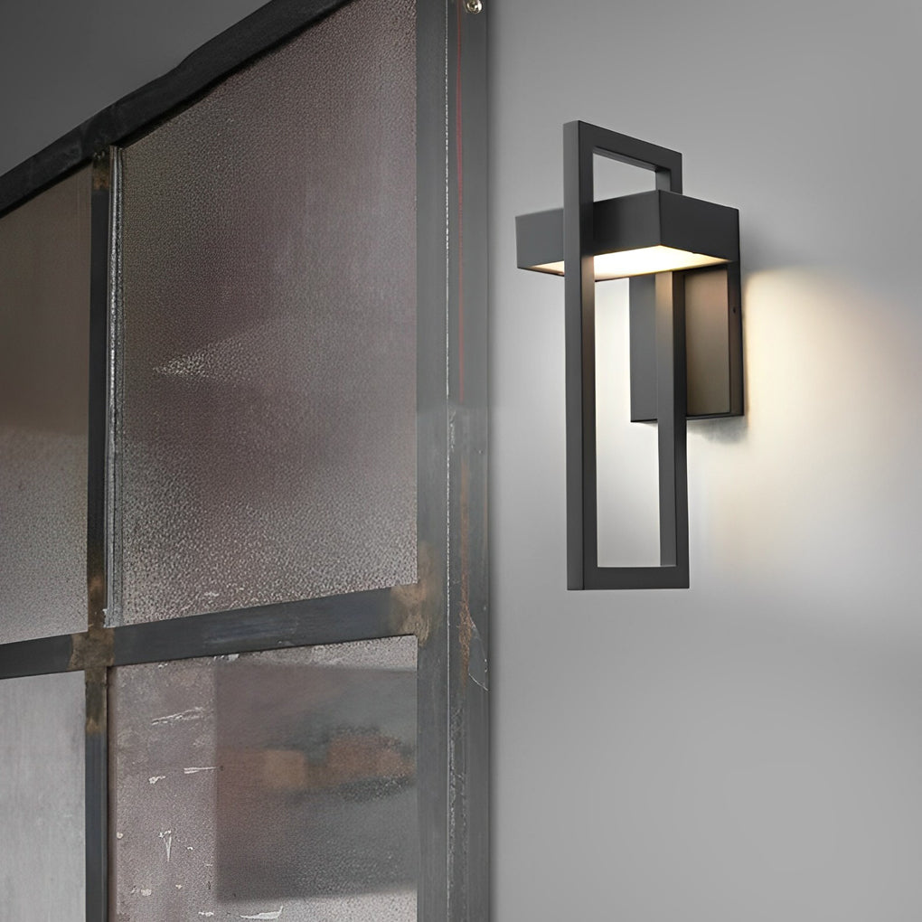 Gold black outdoor wall sconce modern with warm internal glow shown in close up view.
