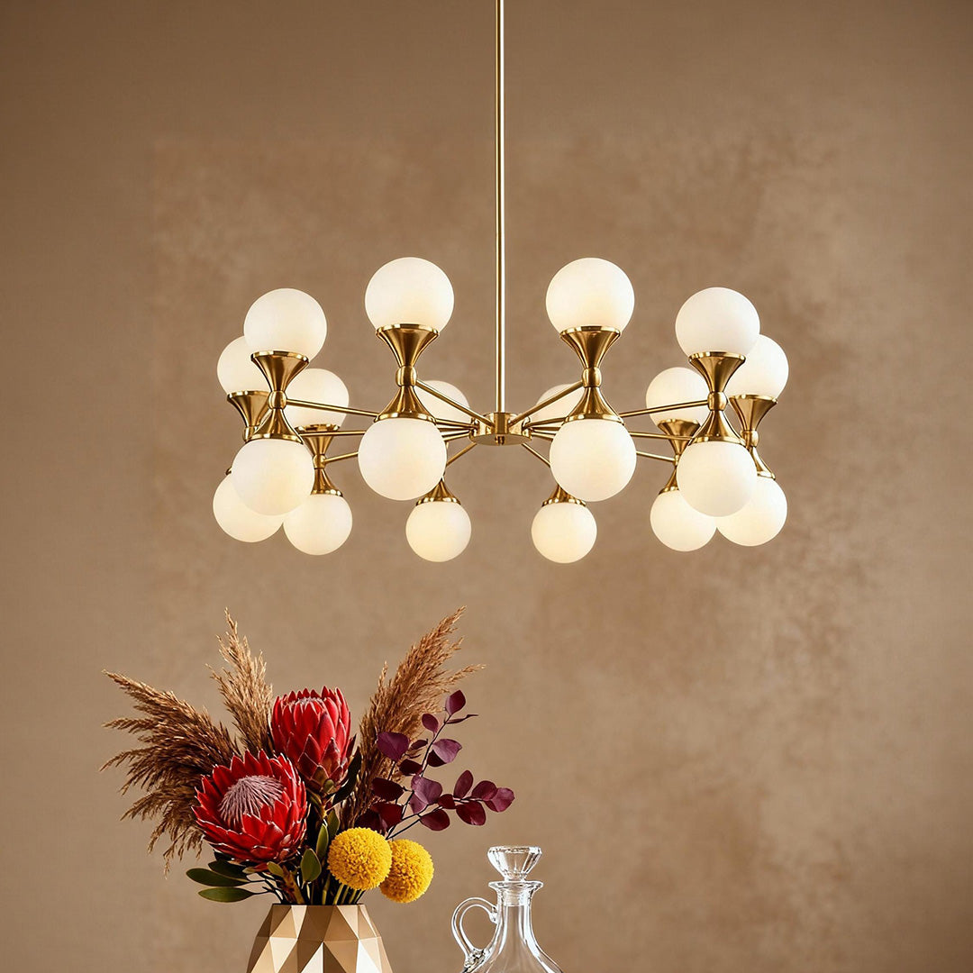 Close up of gold bubble glass chandeliers with frosted shades suspended above a vibrant floral arrangement.