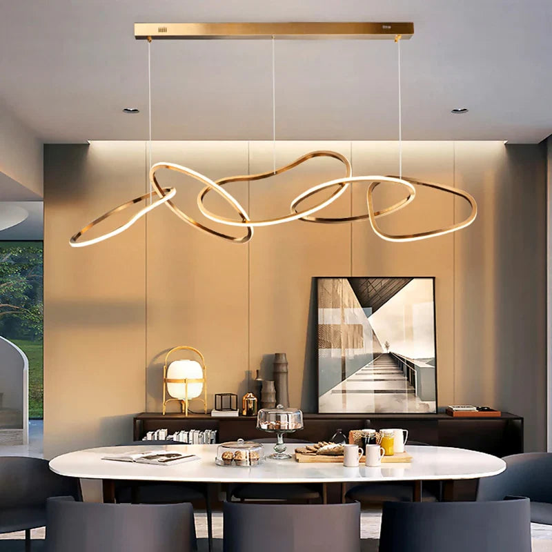 Gold circle chandelier providing elegant illumination above a contemporary dining area.