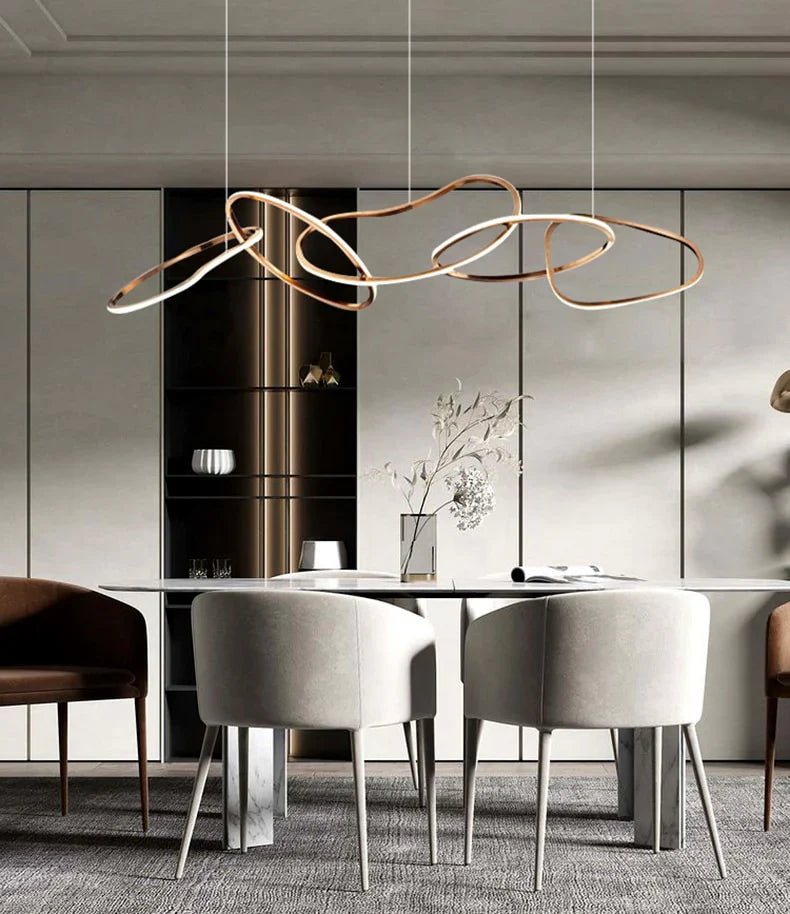 Gold circle chandelier with a modern design, illuminating a round dining table.