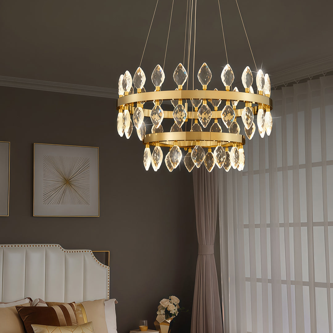 Gold crystorama chandeliers illuminating a cozy bedroom.