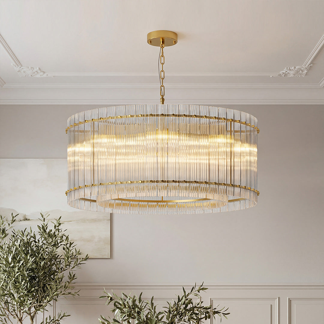 Luxurious gold drum-shaped glass lamp shade chandelier featuring vertical clear glass rods illuminating a sophisticated space.