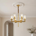 Elegant gold island chandelier modern design featuring angular arms and textured cylindrical glass shades suspended from a classic ceiling medallion.