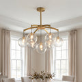 Elegant gold modern glass ball chandelier featuring textured clear glass globes suspended in a bright dining room.
