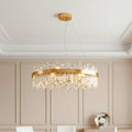 Stunning ring-shaped luxury crystal chandelier featuring a gold band and cascading clear crystal rods in an elegant paneled room.