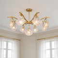 Elegant gold shell chandelier light featuring curved brass arms and textured clear glass shades in a bright room.