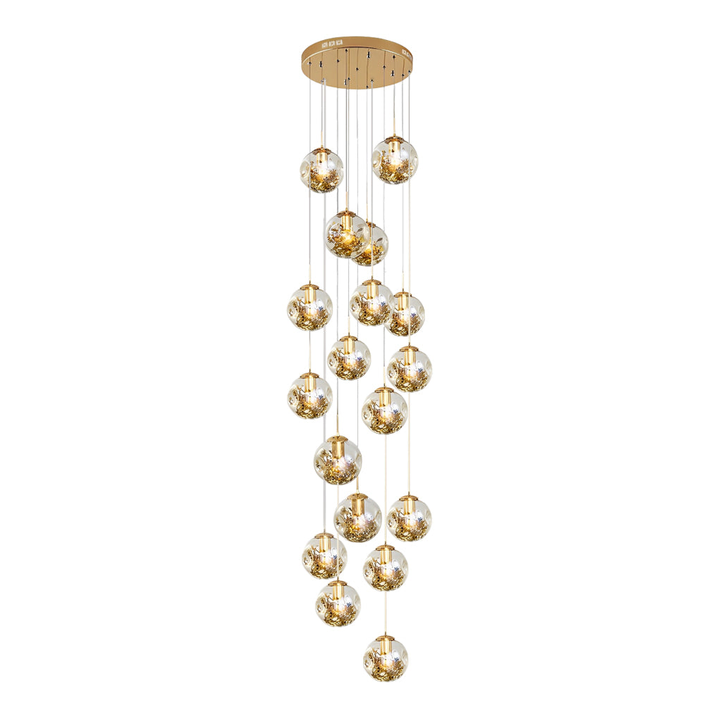 Gold staircase chandelier with a close-up of its hanging crystal and gold detail.