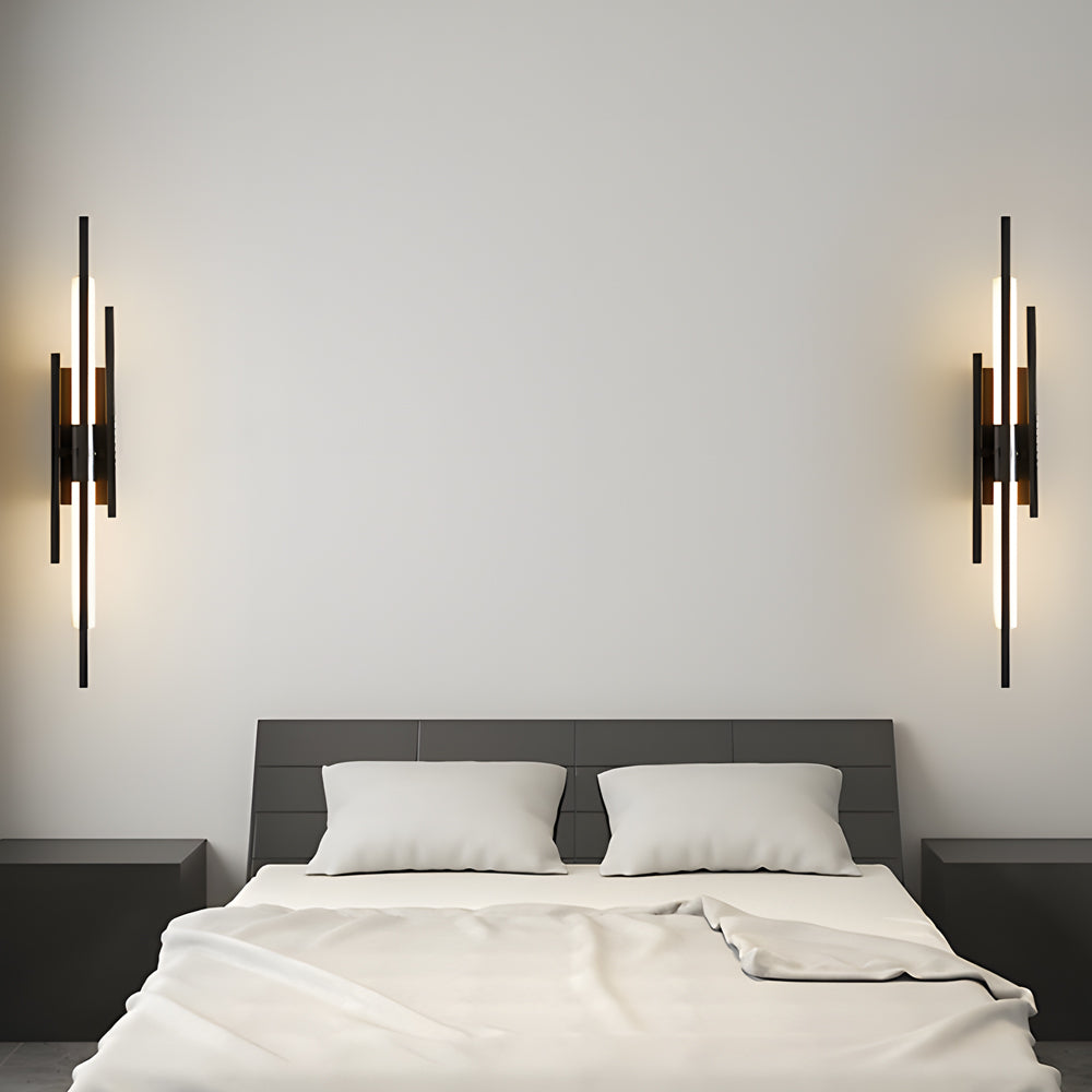 Gold tube wall sconce used as bedside lighting in contemporary bedroom.
