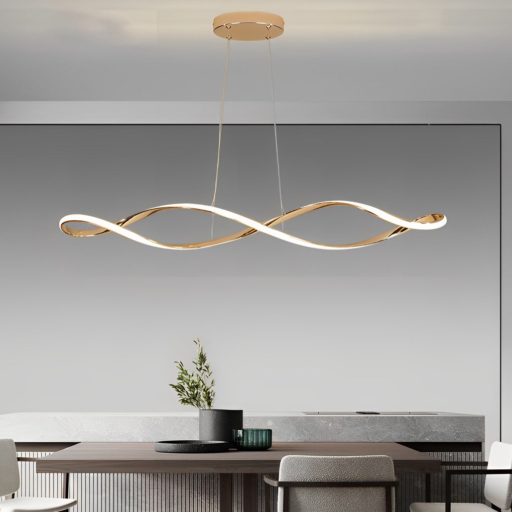 Waveform pendant light in gold finish hanging above dining table with modern decor.