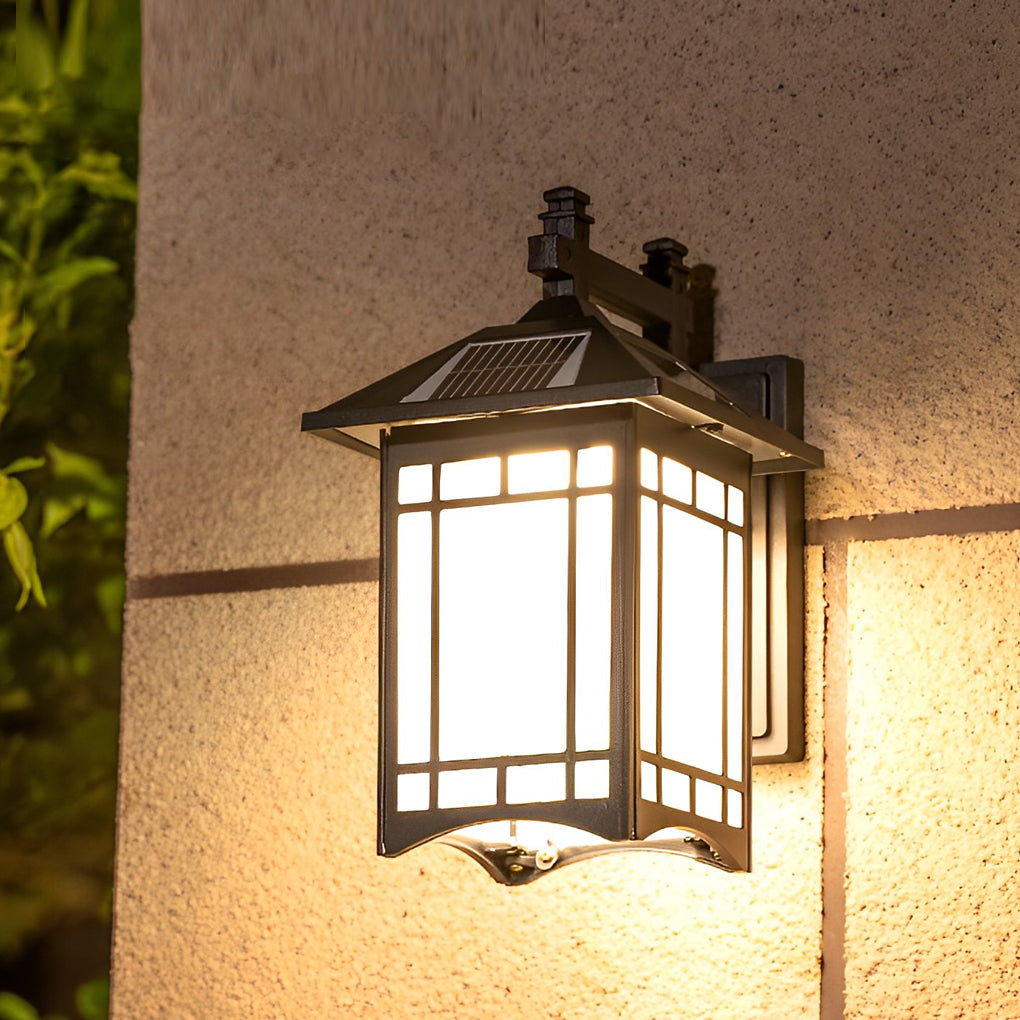 Lantern wall sconce with golden frame and frosted glass panels illuminating outdoor space.