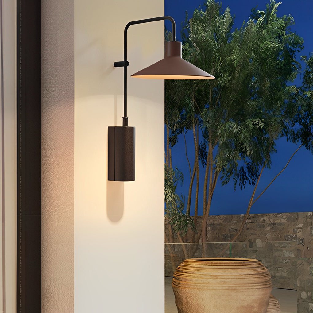 Gooseneck wall lamp mounted on a column near a planter, offering focused outdoor lighting at night.