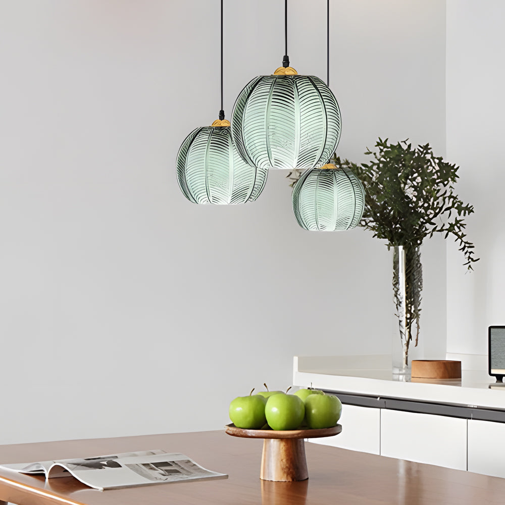 Cluster of green glass pendant lights above a modern dining table with minimalist decor.