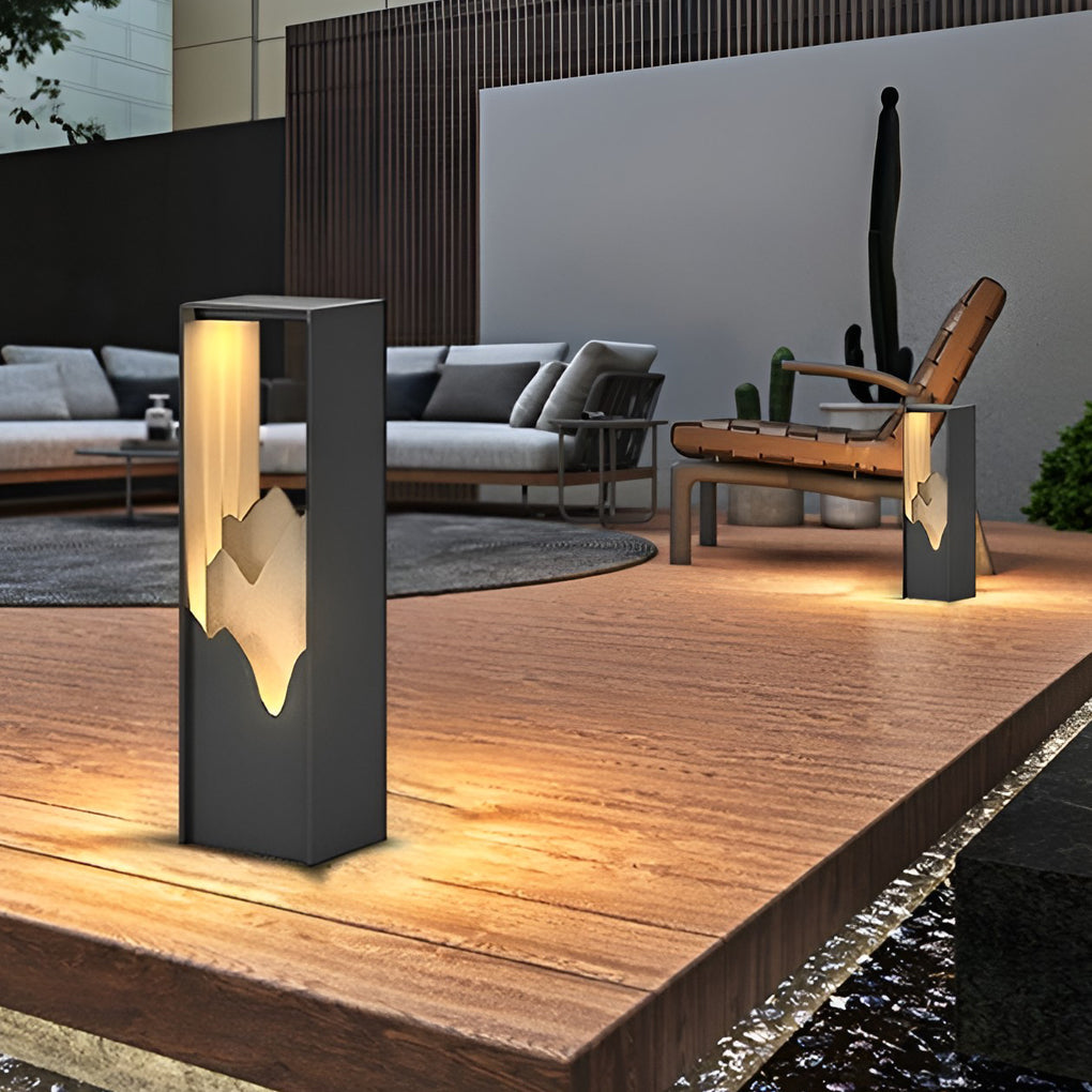 Hollow lawn lamp with mountain-cut design, providing ambient light in a garden.