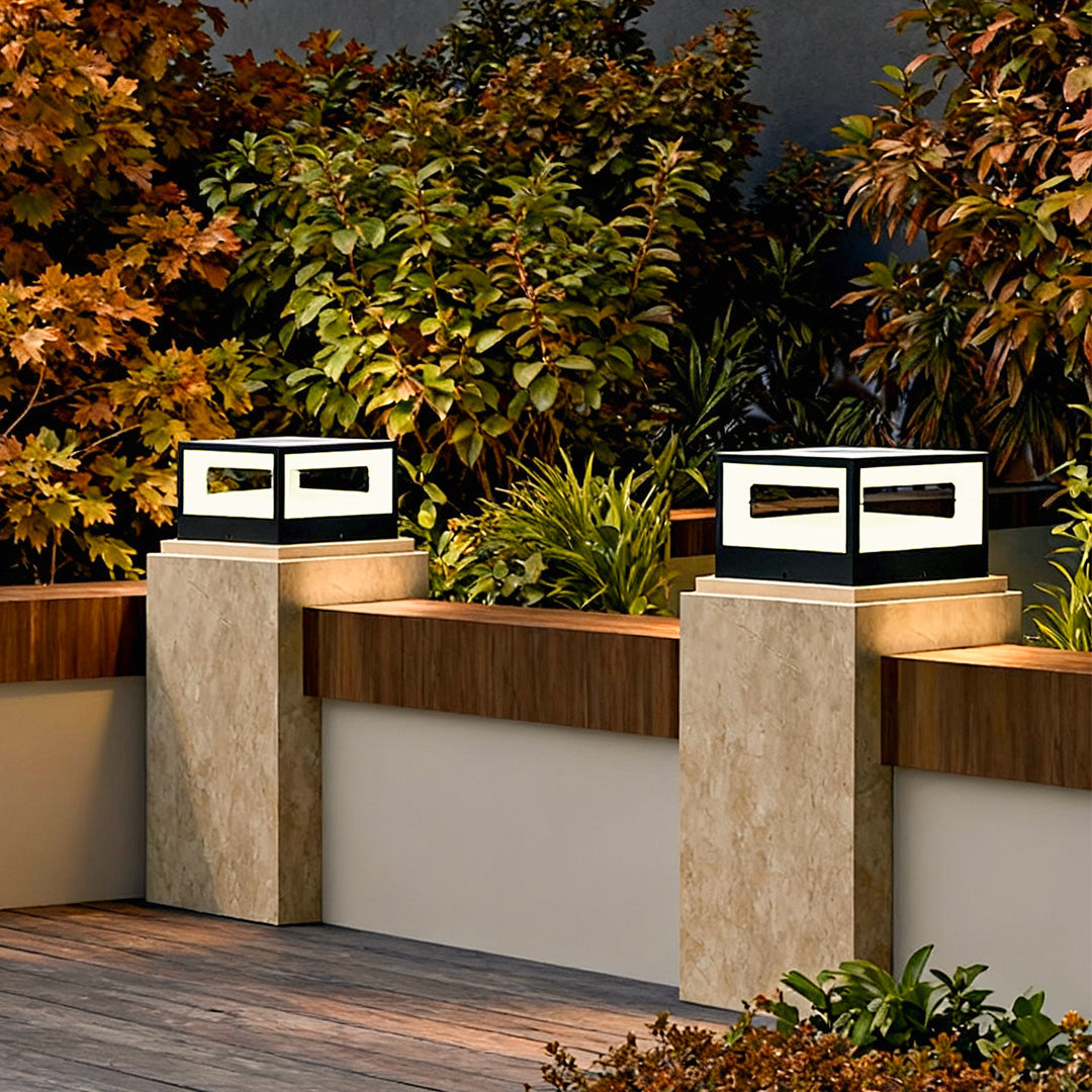 Hollow square pillar light along a garden pathway, casting a soft glow for evening ambiance.