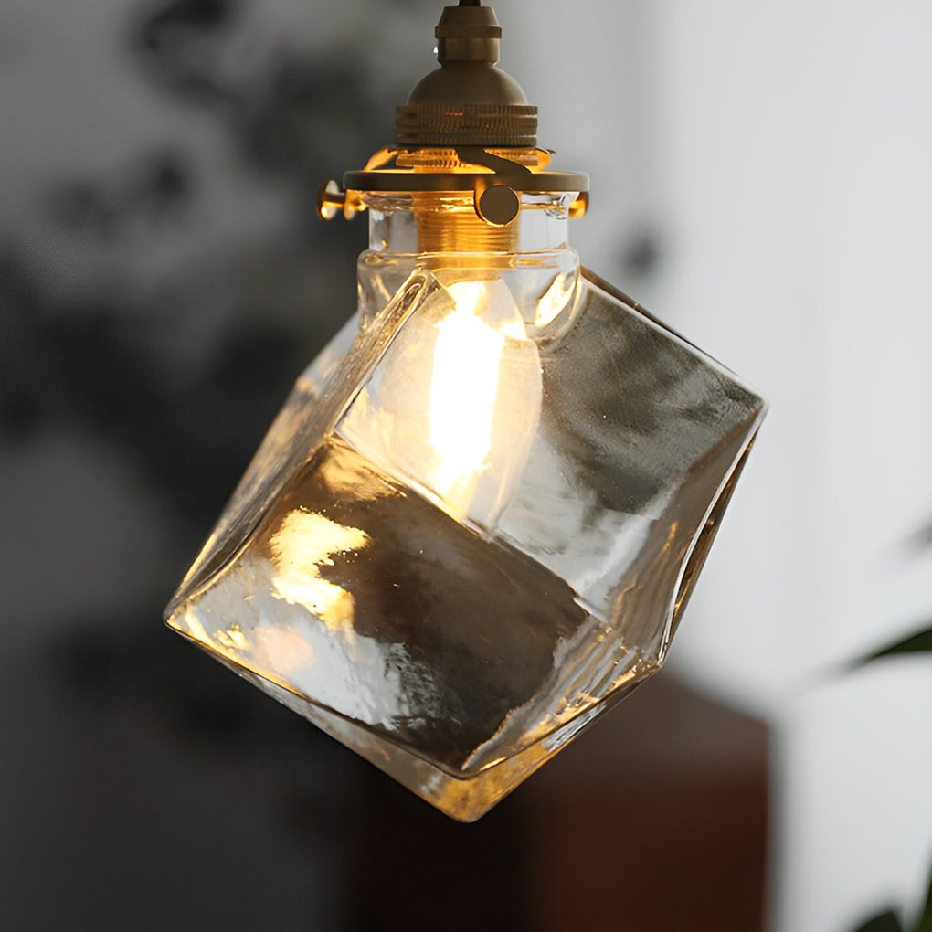 Ice cube glass pendant light close-up showing warm bulb glow inside.