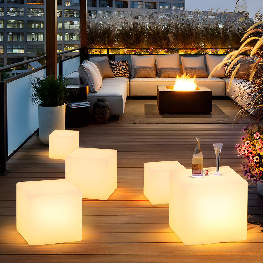 Ice cube LED lights glowing softly, used as decorative tables in an outdoor lounge.