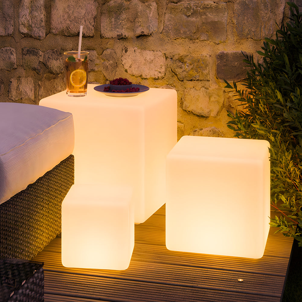 Ice cube LED lights providing warm light, arranged near a cozy outdoor seating area.