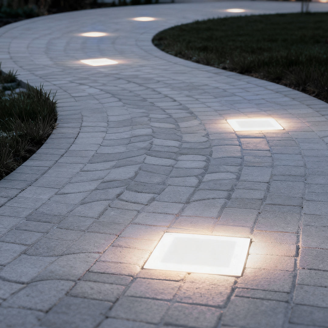 Square ice cube pathway lights embedded in a curved paved walkway.