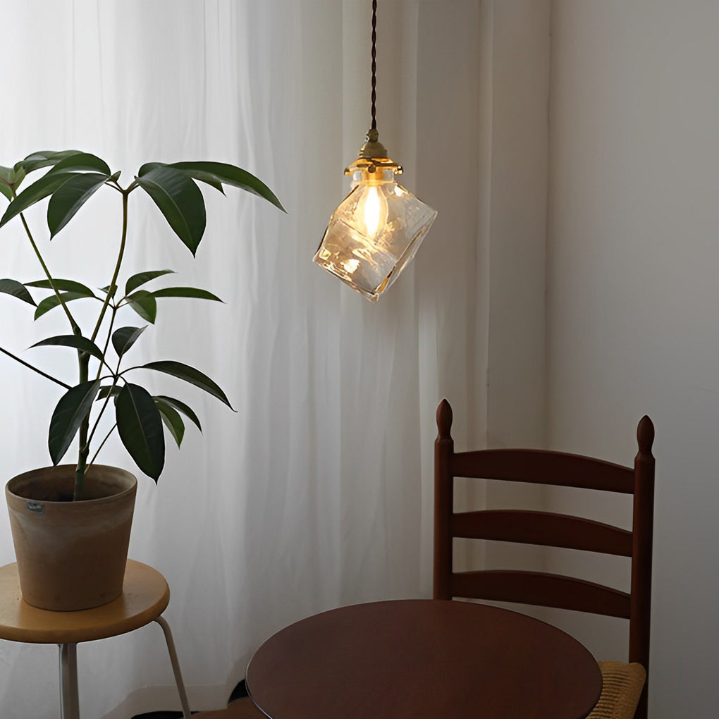 Ice cube pendant light hanging above a small table with indoor plant.
