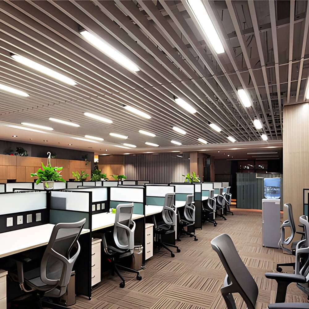 Industrial linear lighting in a modern open-plan office with workstations.