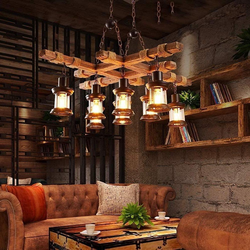 Industrial rustic wood chandelier with lantern glass shades in cozy living room.