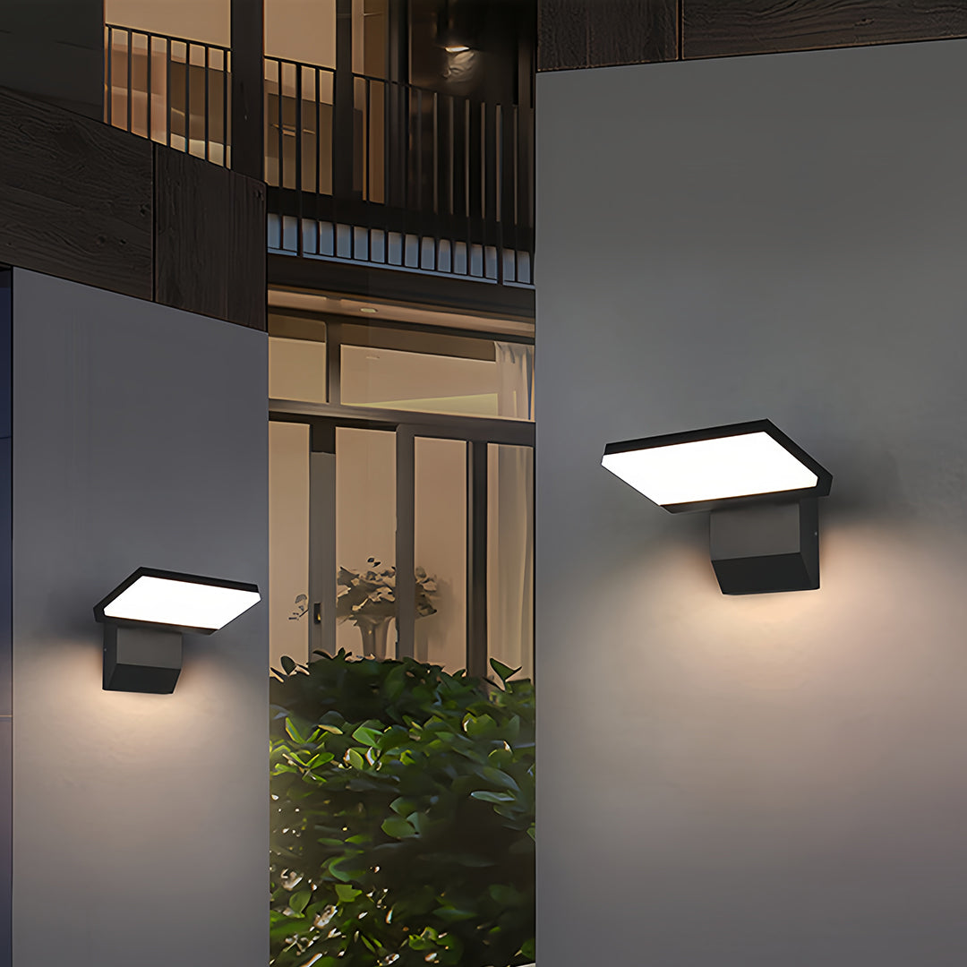 Industrial wall lights mounted on modern building exterior illuminating entrance at evening