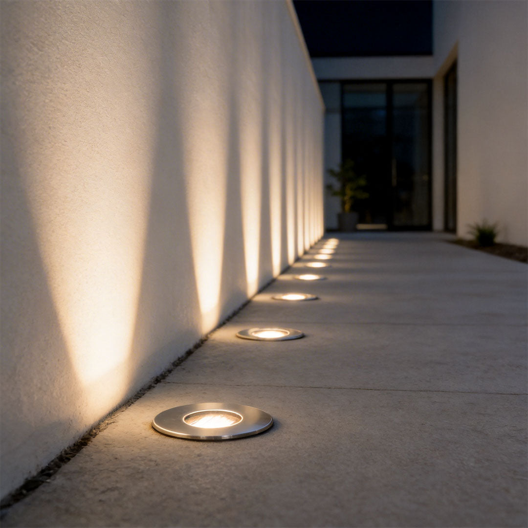 Inground well light with a sleek design, illuminating a modern house pathway.