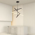 Iron linear chandelier installed in minimalist beige room with white furniture and wood accent wall.