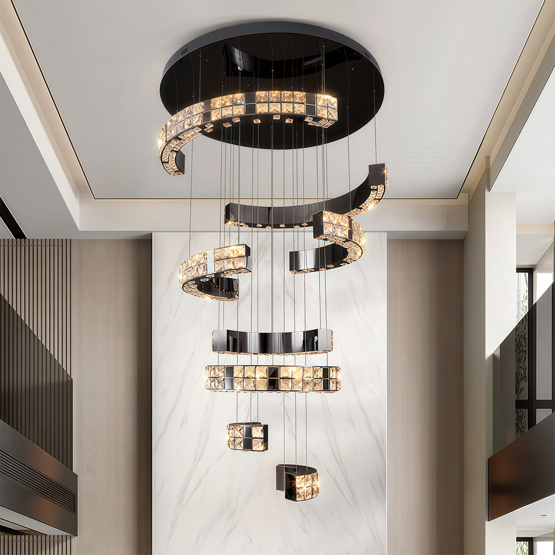 Large K9 crystal chandelier installed above a staircase in modern home.