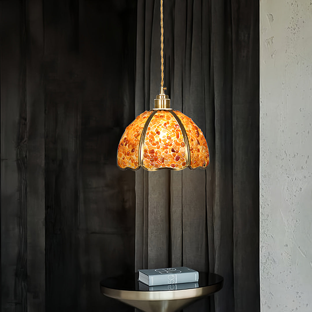 Small crystal pendant light illuminating modern kitchen island with dark cabinetry