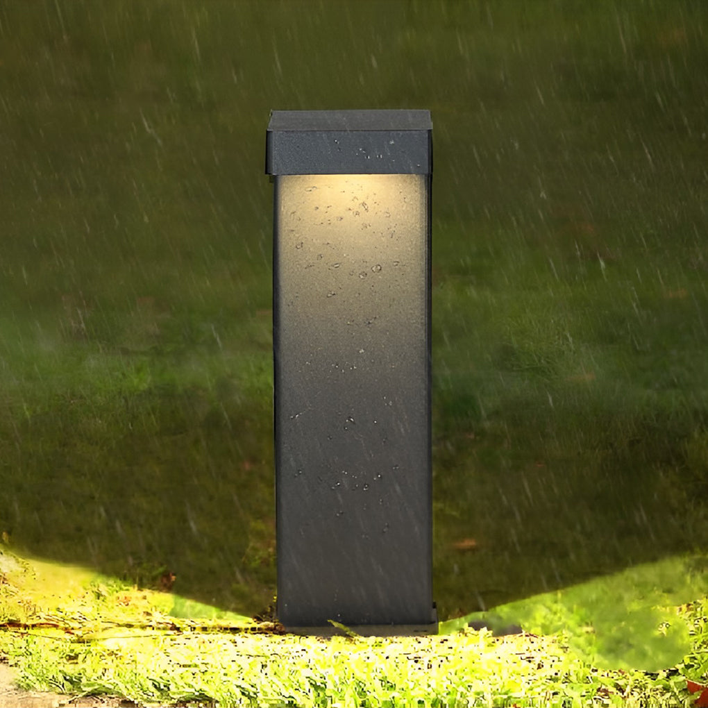 L shaped landscape light with a modern black design, illuminating a garden pathway.