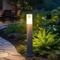 Bright landscape bollard light fixtures lining a backyard garden path, providing warm directional illumination.