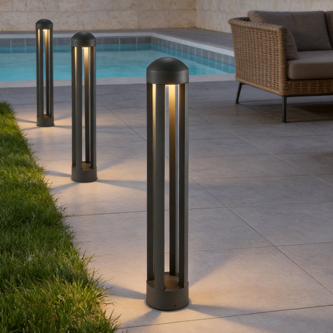 Landscape bollard lights providing soft illumination along a stylish poolside walkway.