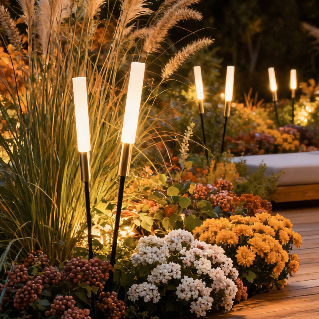 Landscape light spikes casting a gentle glow on colorful flowers and foliage, perfect for accentuating outdoor garden features.