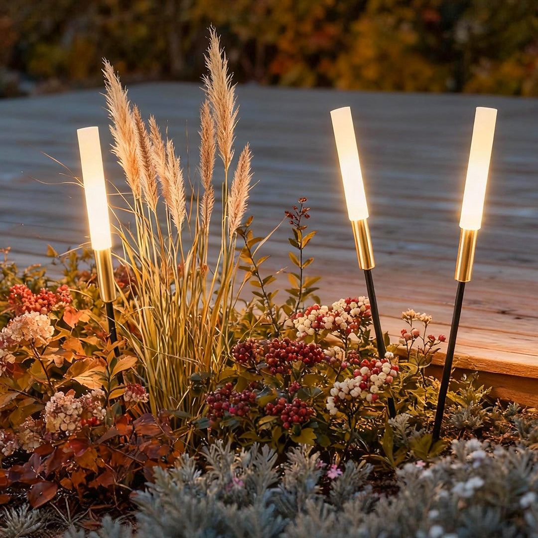 Landscape light spikes installed among plants and flowers, enhancing the beauty of garden beds with subtle lighting.
