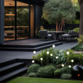 An outdoor deck and staircase bordered with glowing globe pathway lights, adding functional illumination to the landscape lighting pathway.