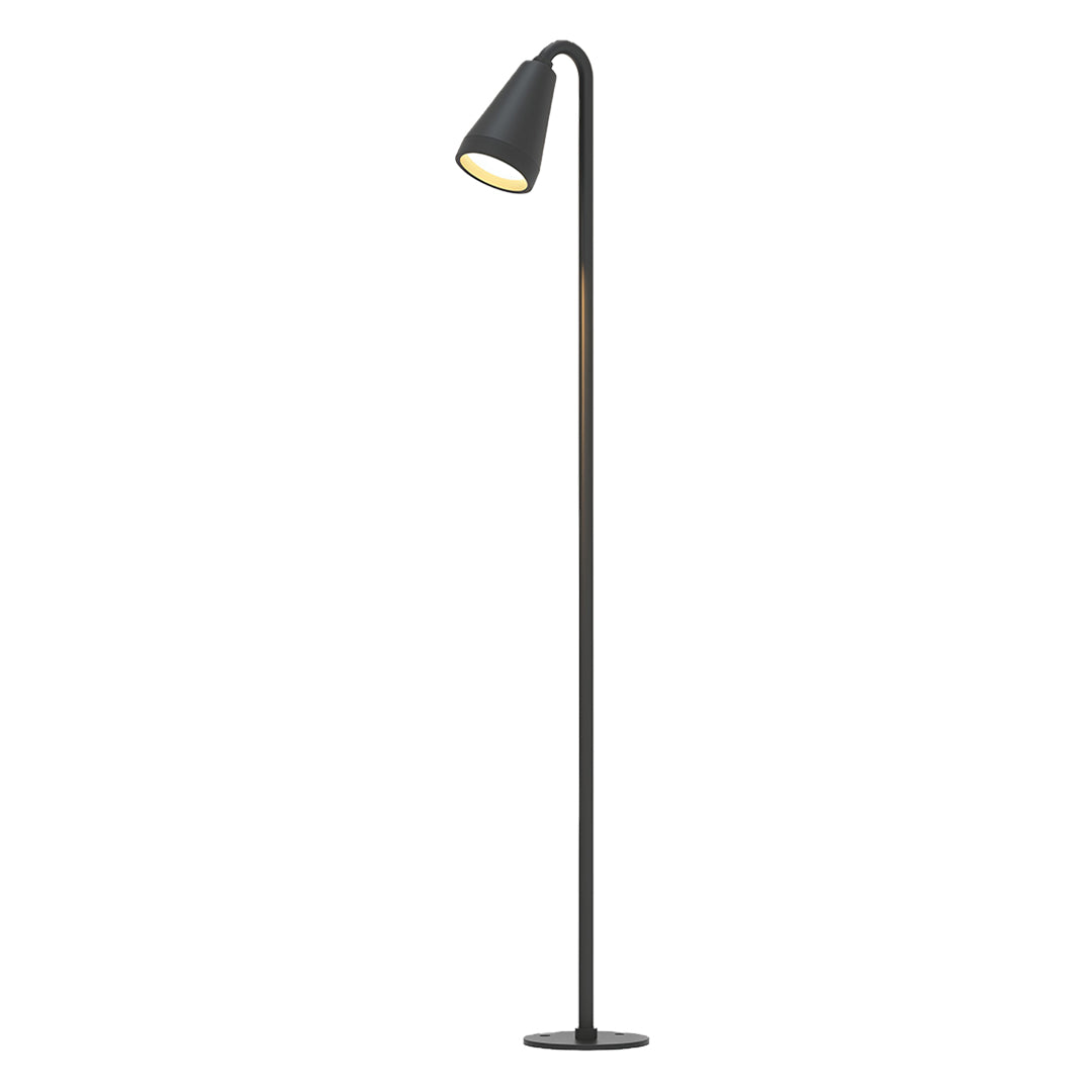 Landscape path light installed in a garden with tropical plants, providing warm and inviting illumination.