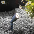 Landscape spotlight positioned in green lawn creating directional lighting for garden accent illumination