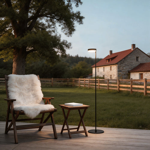 Elegant large black outdoor pillar light illuminating a cozy garden patio with stone pillars and wicker furniture.