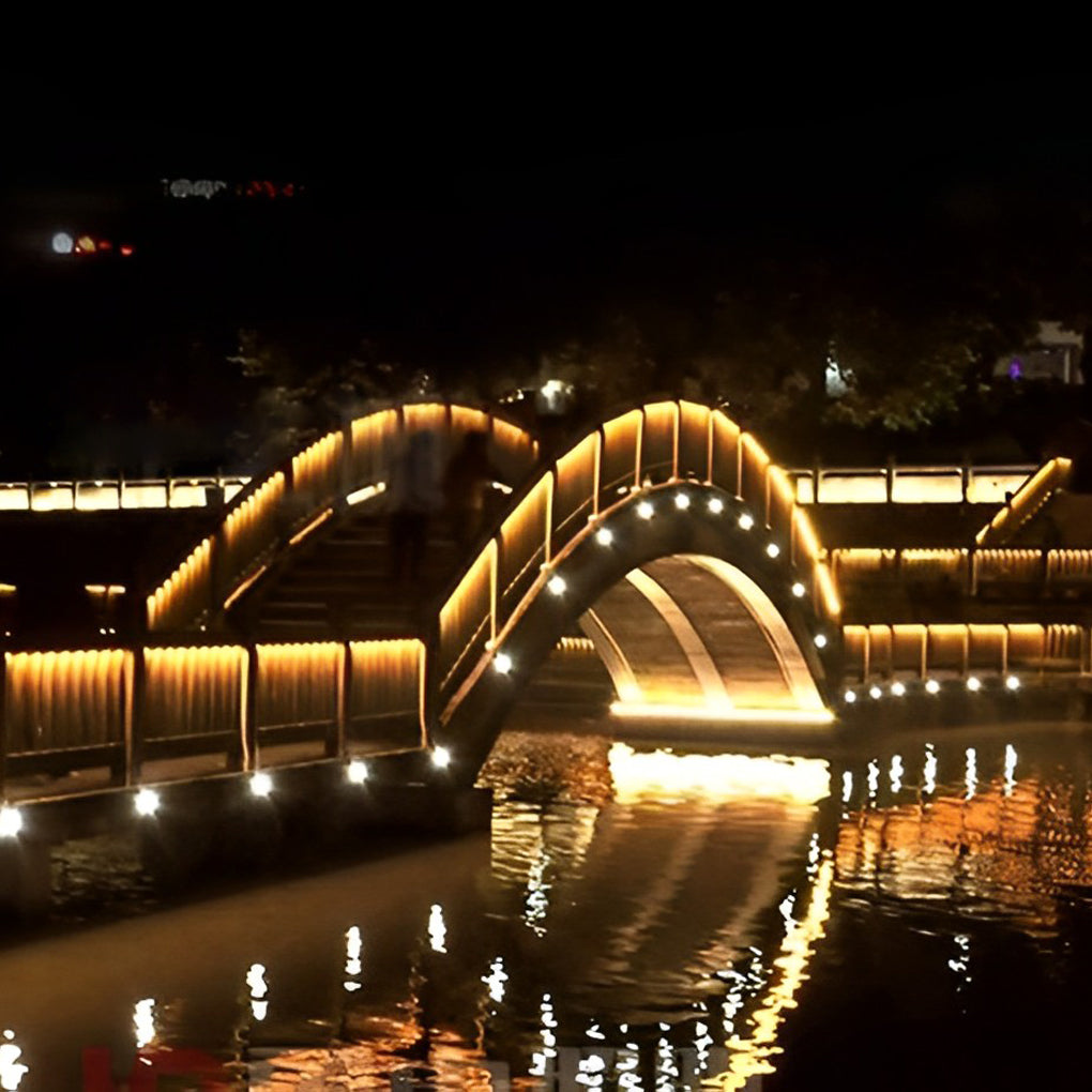 LED building facade lighting enhancing a bridge and water feature for dramatic nighttime landscape lighting.