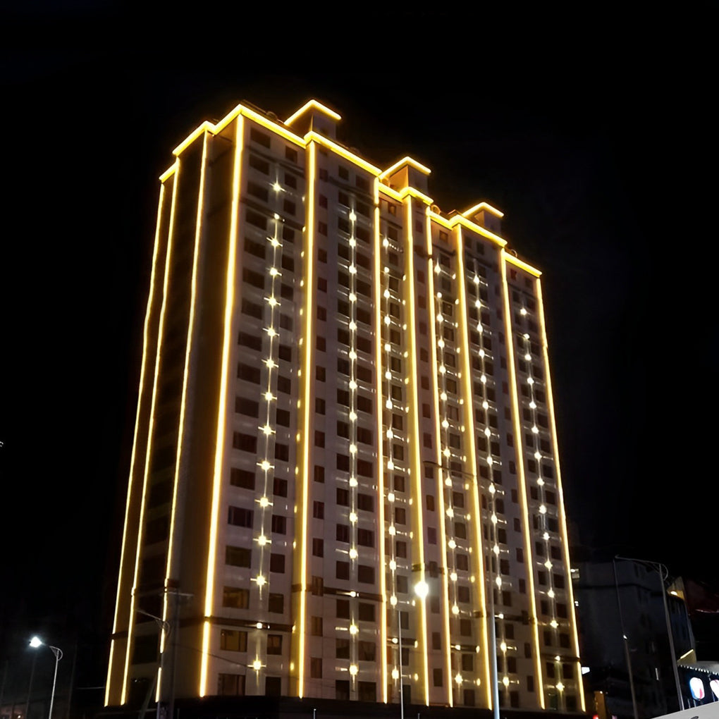 Tall building adorned with vertical LED building facade lighting for striking nighttime architectural illumination.