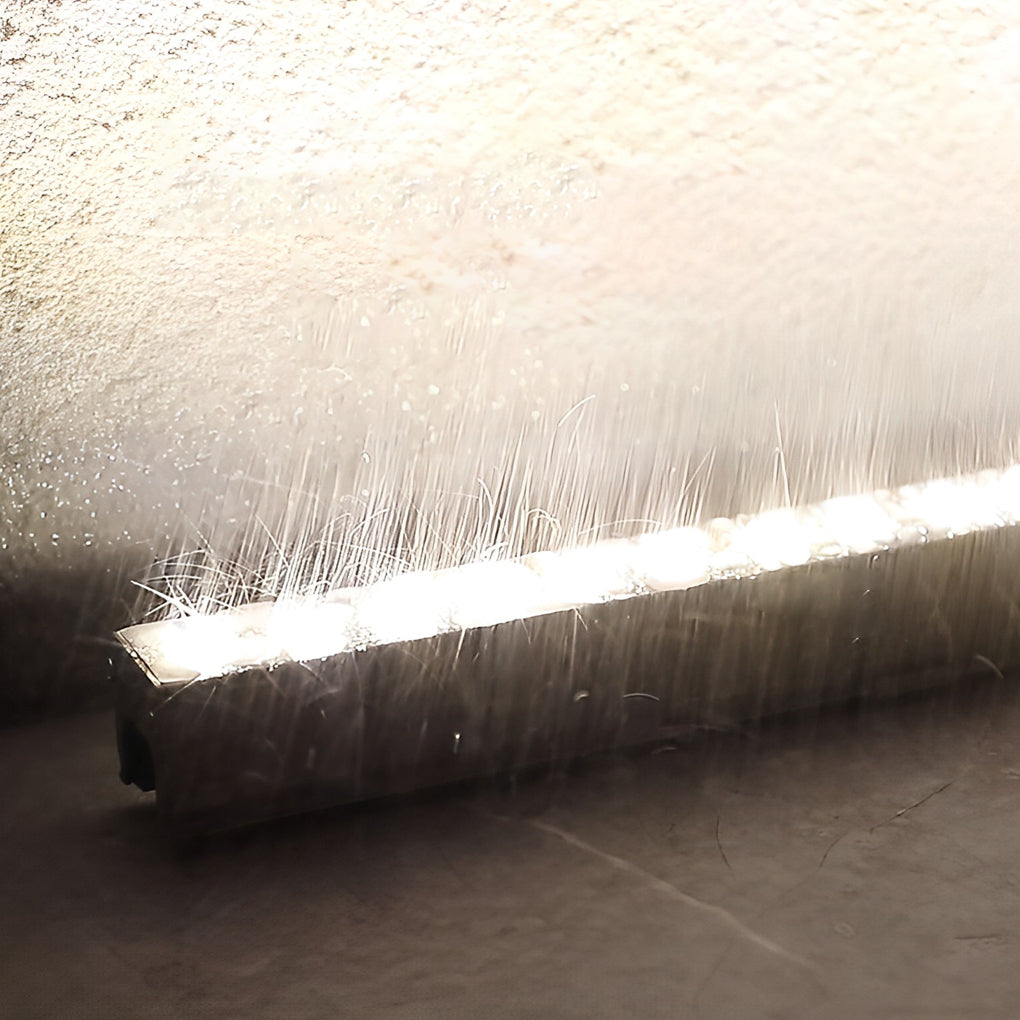 Close up of LED building facade lighting creating a waterfall effect with linear light strips and smooth surface.