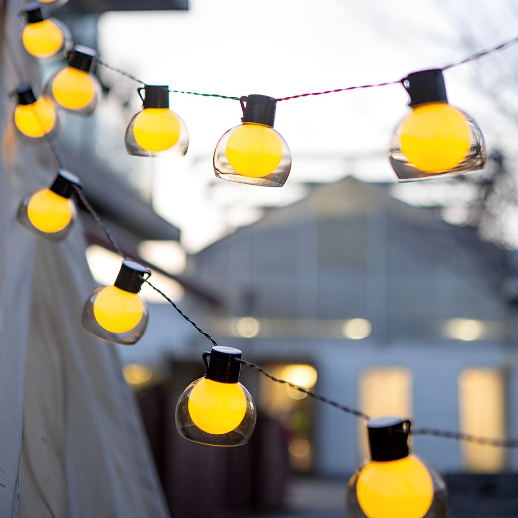 LED globe string lights draped diagonally across an outdoor staircase, creating a warm and welcoming pathway glow.