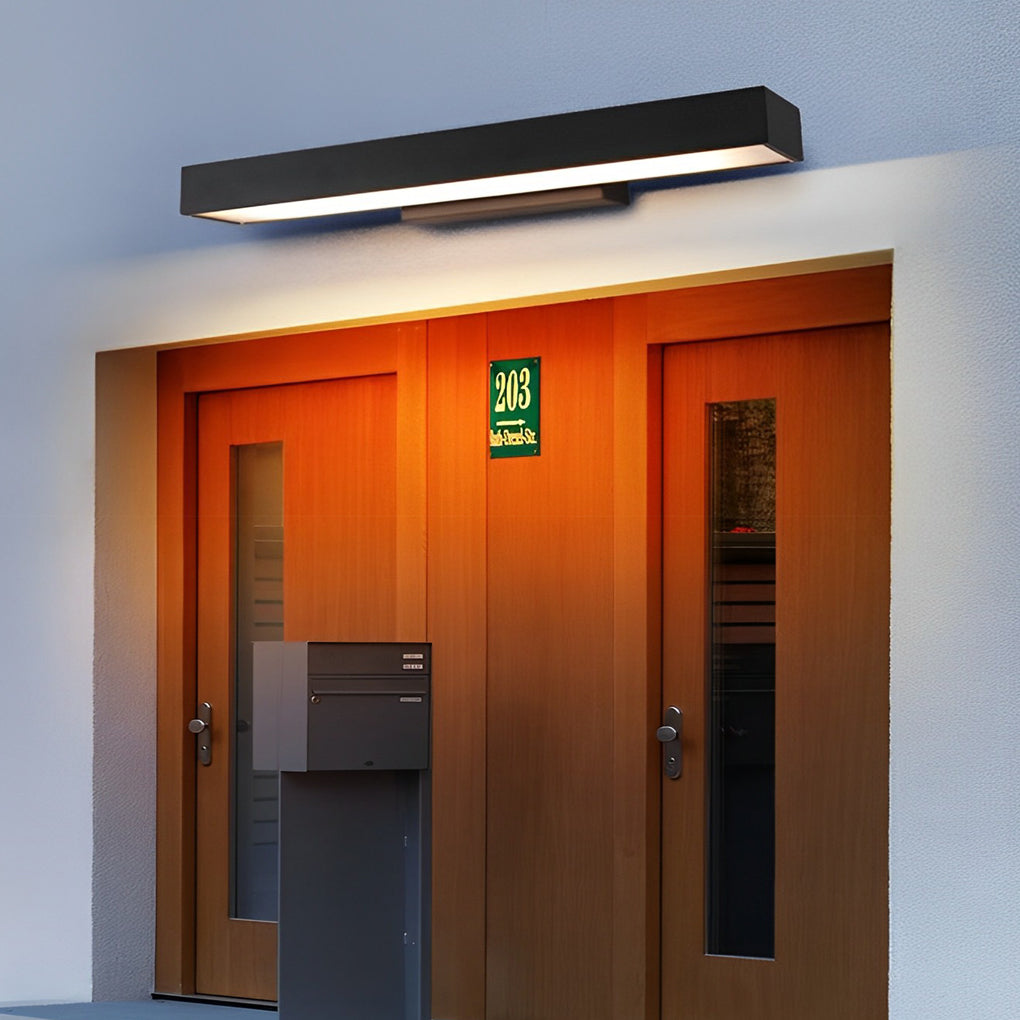 LED linear wall light above a residential entrance, casting warm light that highlights the doorway and surrounding facade.