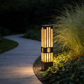 LED marble bollard light illuminating a garden pathway with a warm, elegant glow.